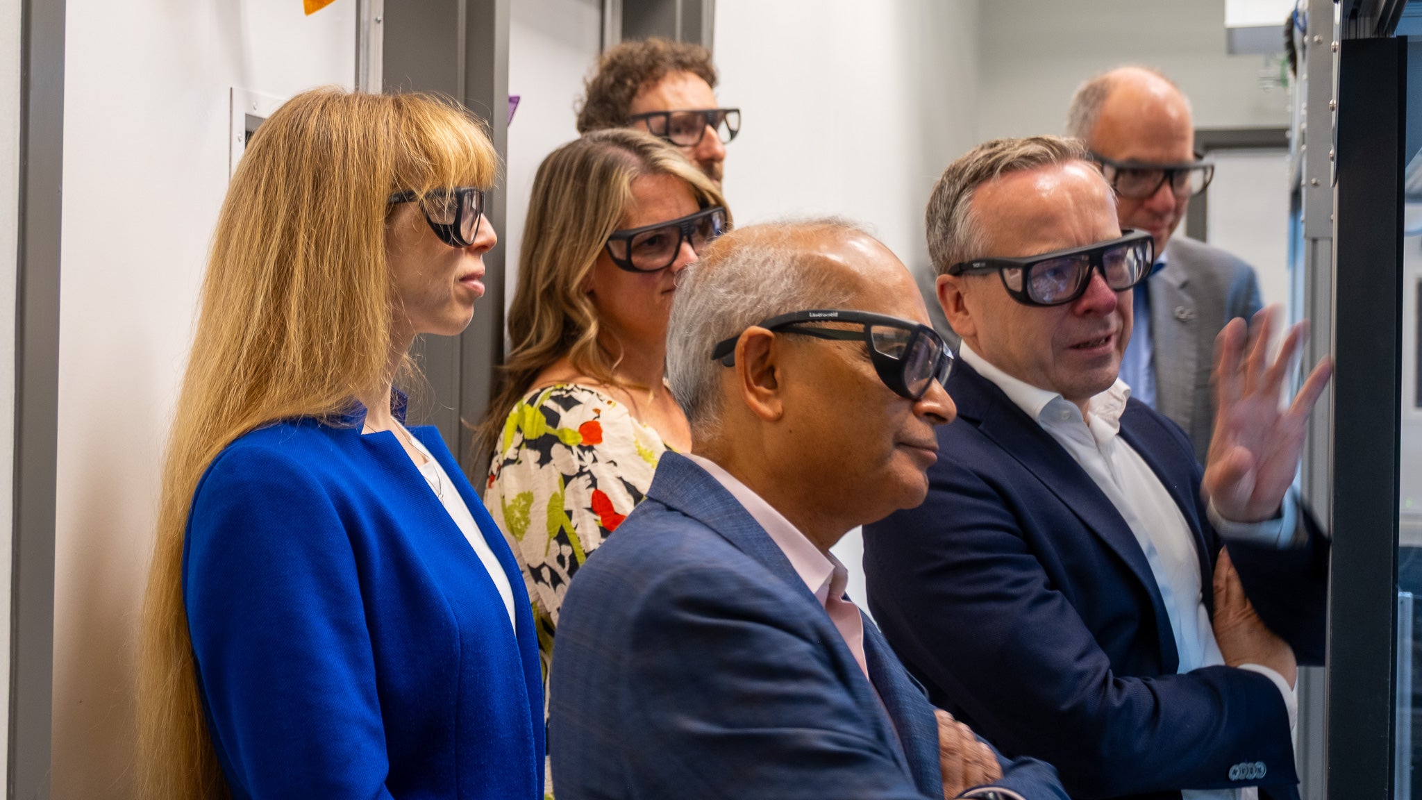 six people wearing protective glasses in a quantum science lab