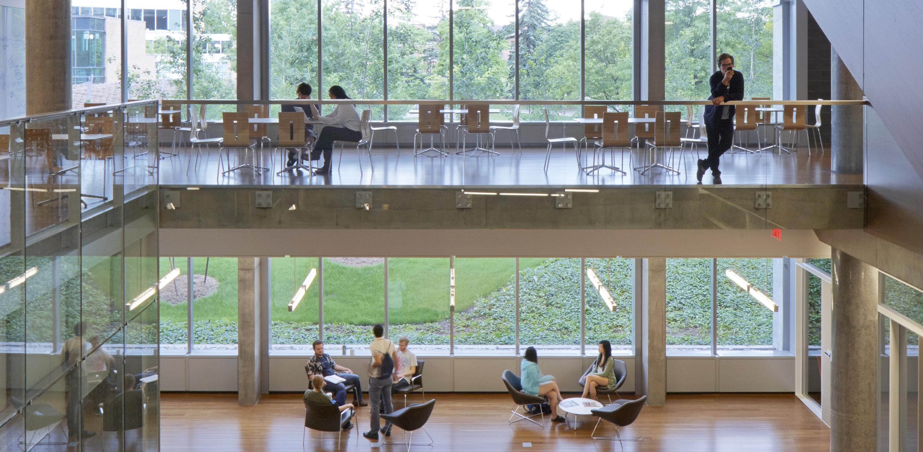 Groups of Institute members sitting in IQC's two-storey common space