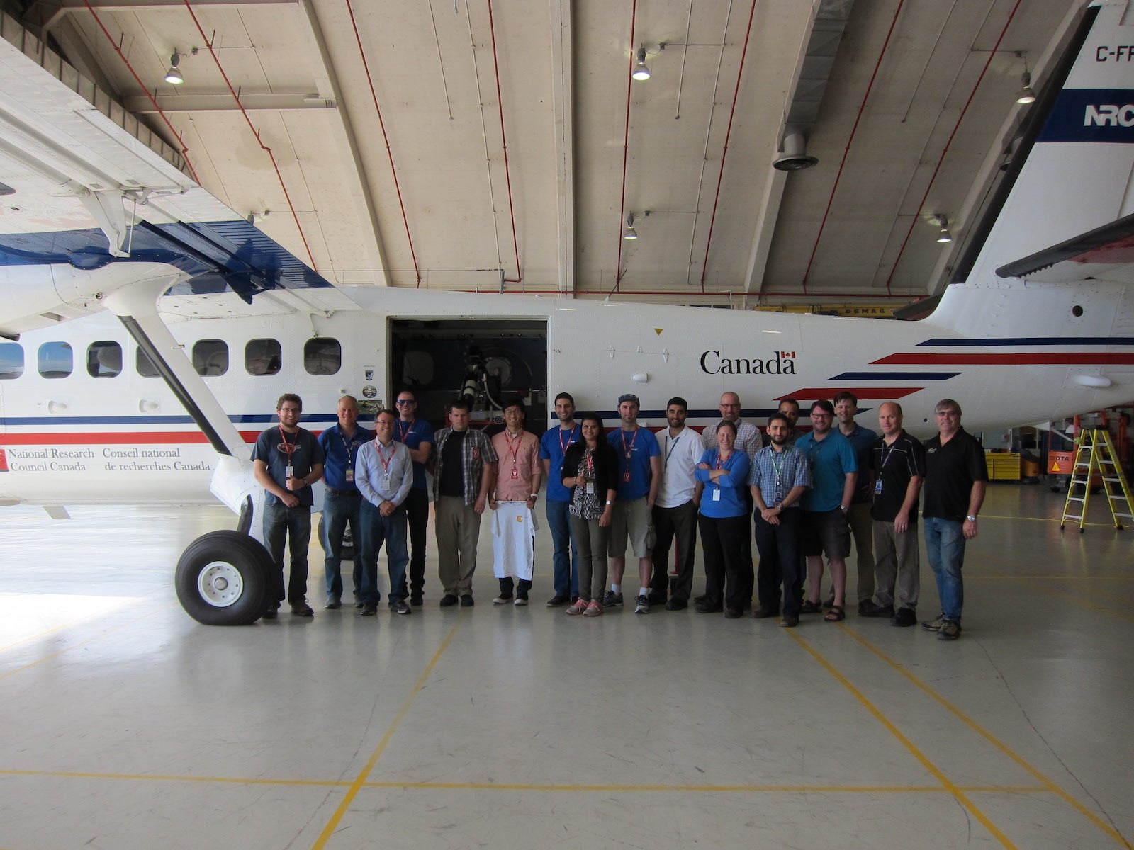 QKD airborne demonstration - a plane sits in the hanger in Smith Falls, Ottawa with a team of researchers standing by.