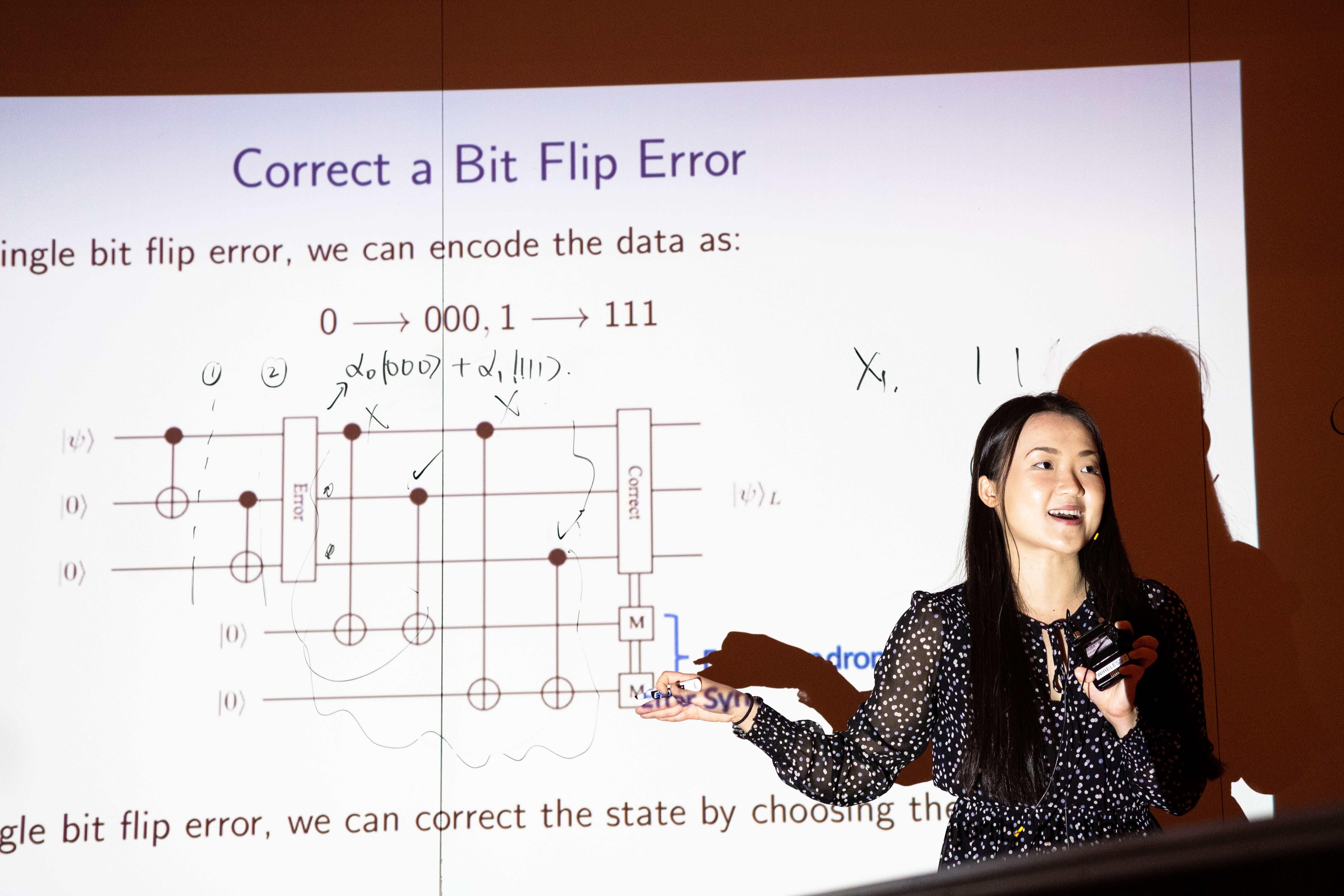 A QSYS presenter explaining "Bit Flip Error Correction" with the use of a slide