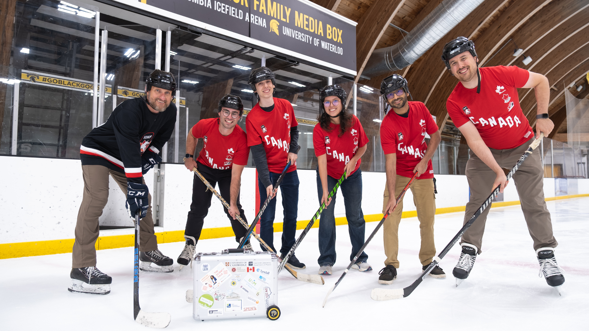 A group of six researchers from Quantum Photonic Devices Laboratory wearing hockey gear on Waterloo's ice rink