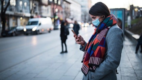 Women on a phone wearing a mask