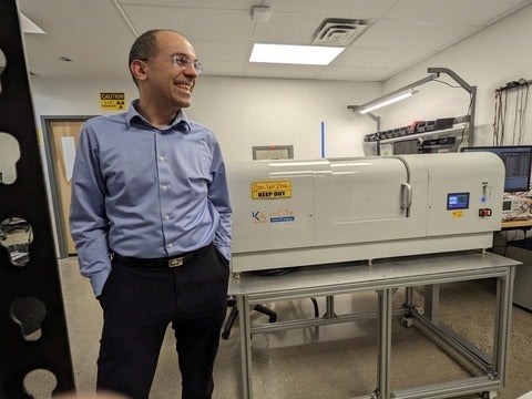 Professor Karim standing next to and x-ray scanner