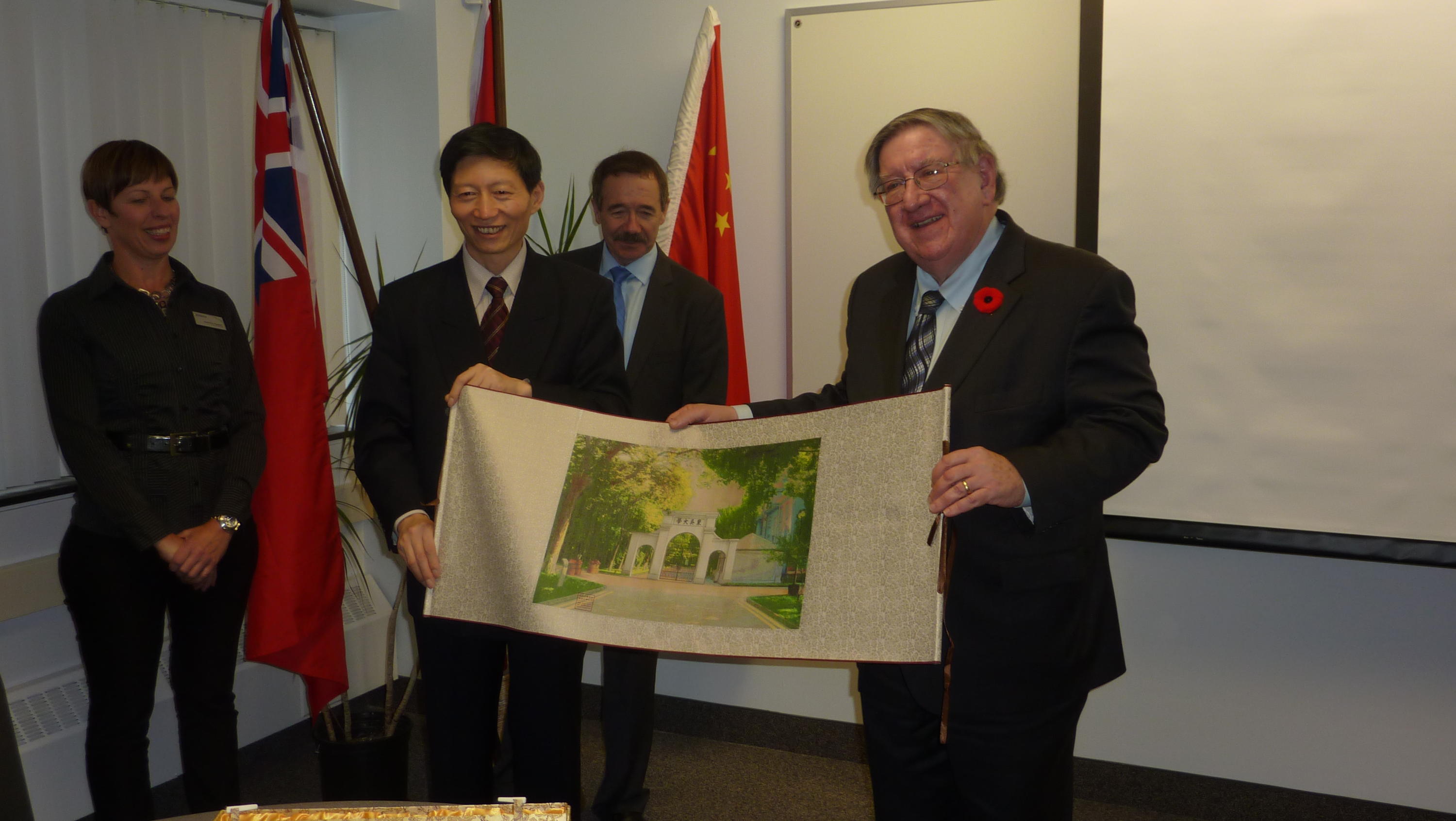George Dixon, Terry McMahon, and the Soochow University president holding image of Soochow University gates