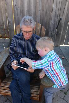 Child helping man with ipad