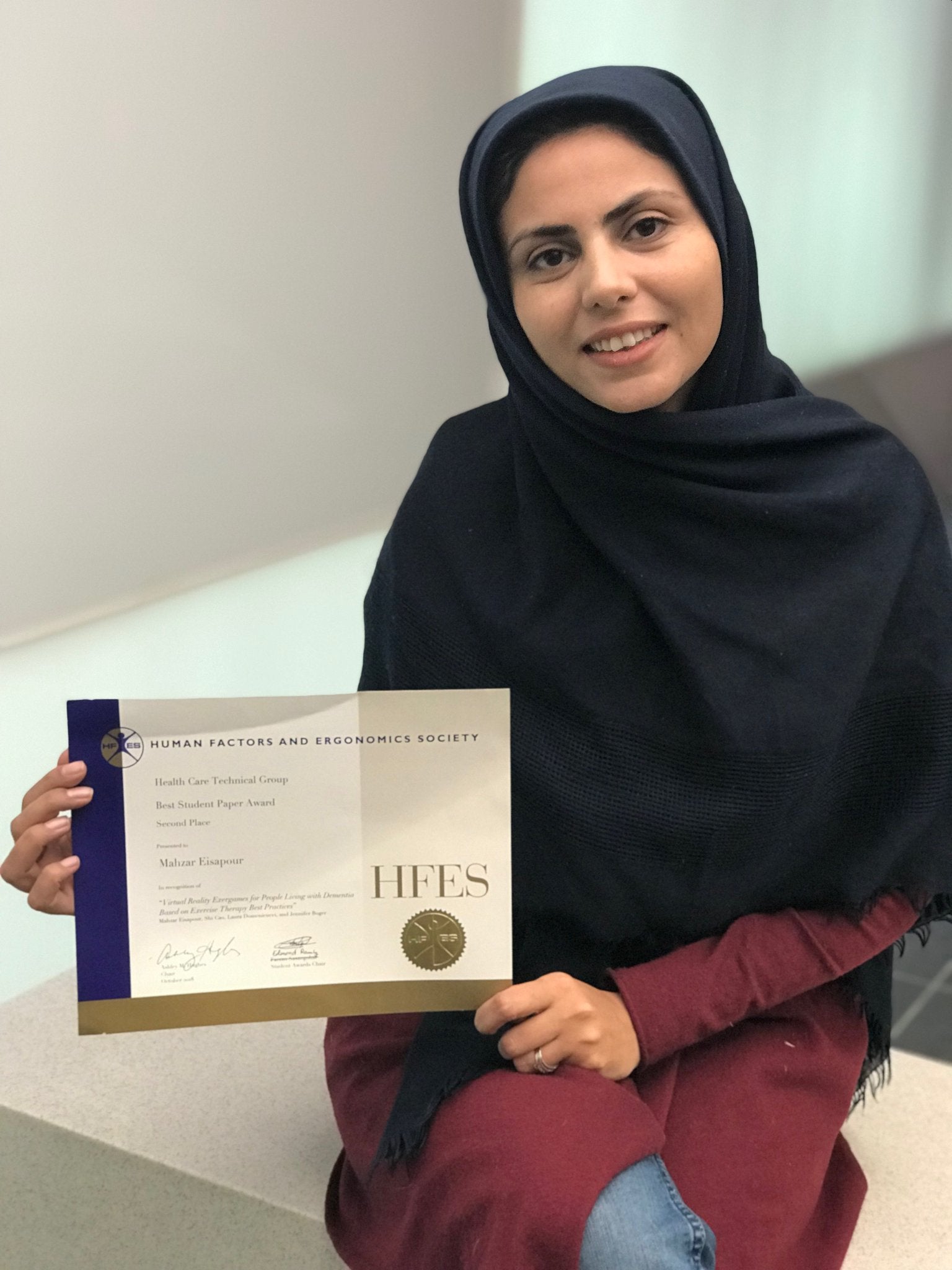 Photo of Mahzar holding her best paper award certificate 