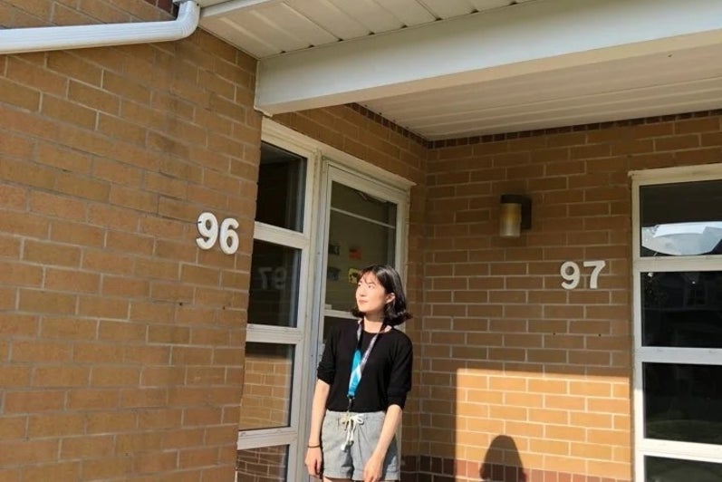 Si Yon posing outside the front door of her campus residence.