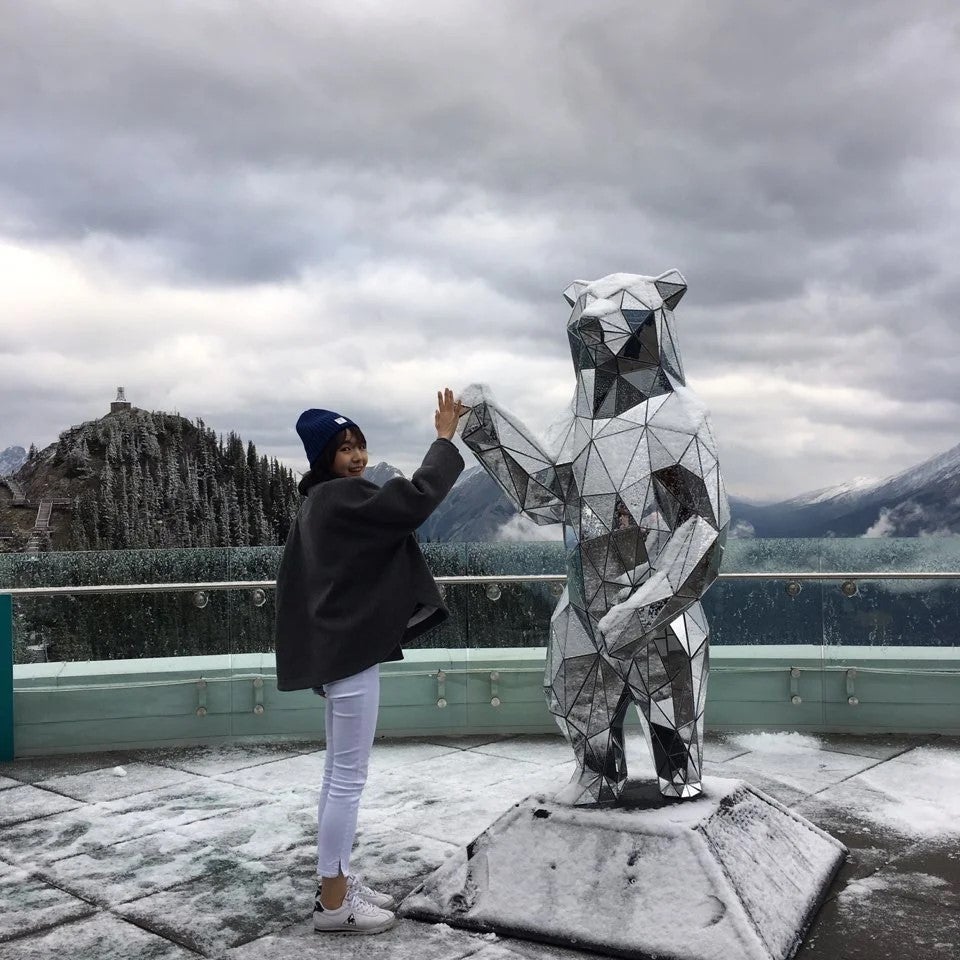 Si Yon high fiving the mirror bear statue in Banff, Alberta.