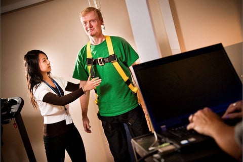 Co-op student works with stroke survivor in rehabilitation setting.
