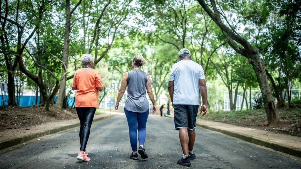Three people walking in a park.