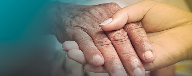 caregiver hand clasping older adult hand