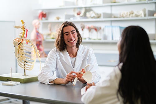 Student talks to teaching assistant in the human anatomy lab.