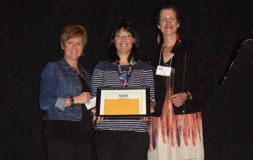 Diana DeCarvalho holds Founders' Award plaque.
