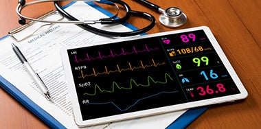 Electronic tablet with graphics of health monitors, a stethescope, and a clipboard and pen