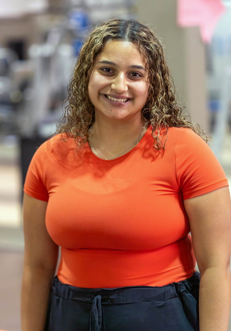 Jasmine Nitsotolis standing smiling in a gym.