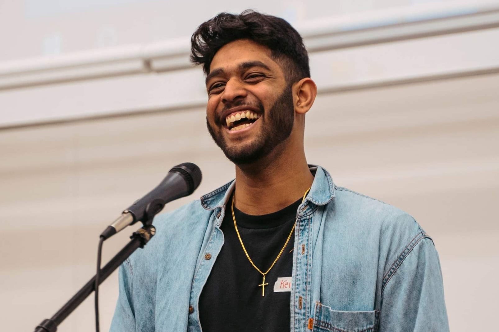 Keith Rajkumar smiling and talking into a microphone 