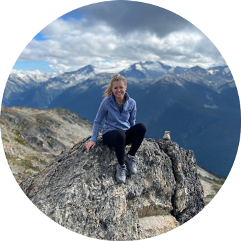 Kylie Sullivan sitting on a rock on a mountain