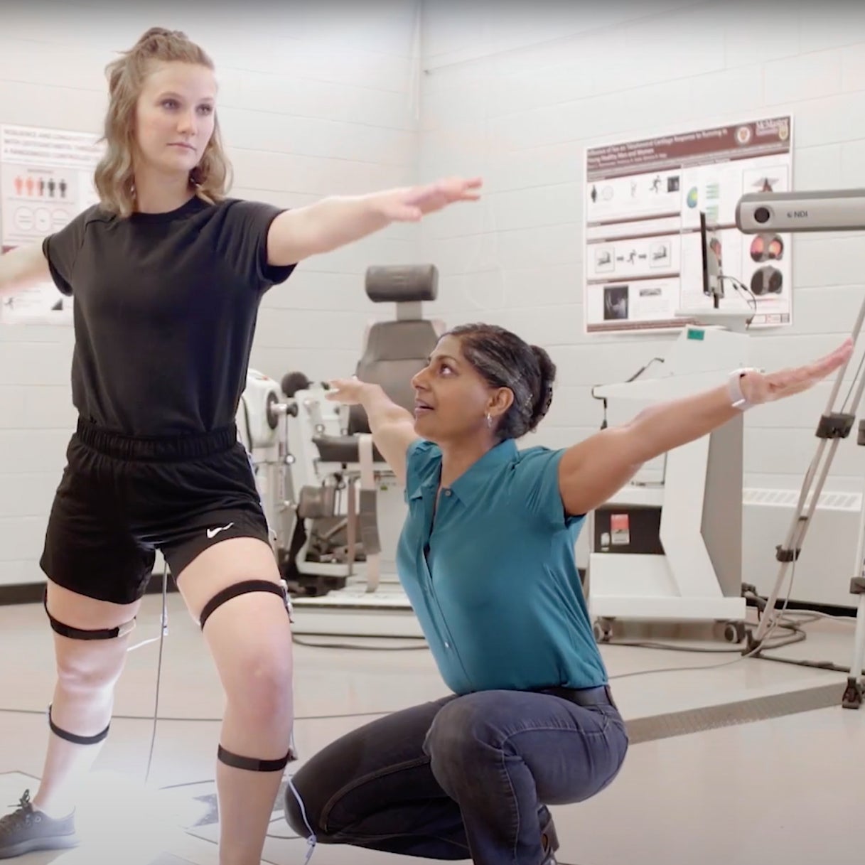 Graduate student and professor doing movement study with arms out to the side