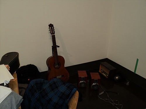 Guitar and speakers in corner of gallery.