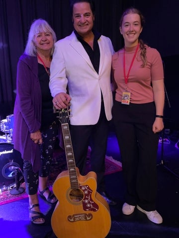 Sylvie standing with two performers