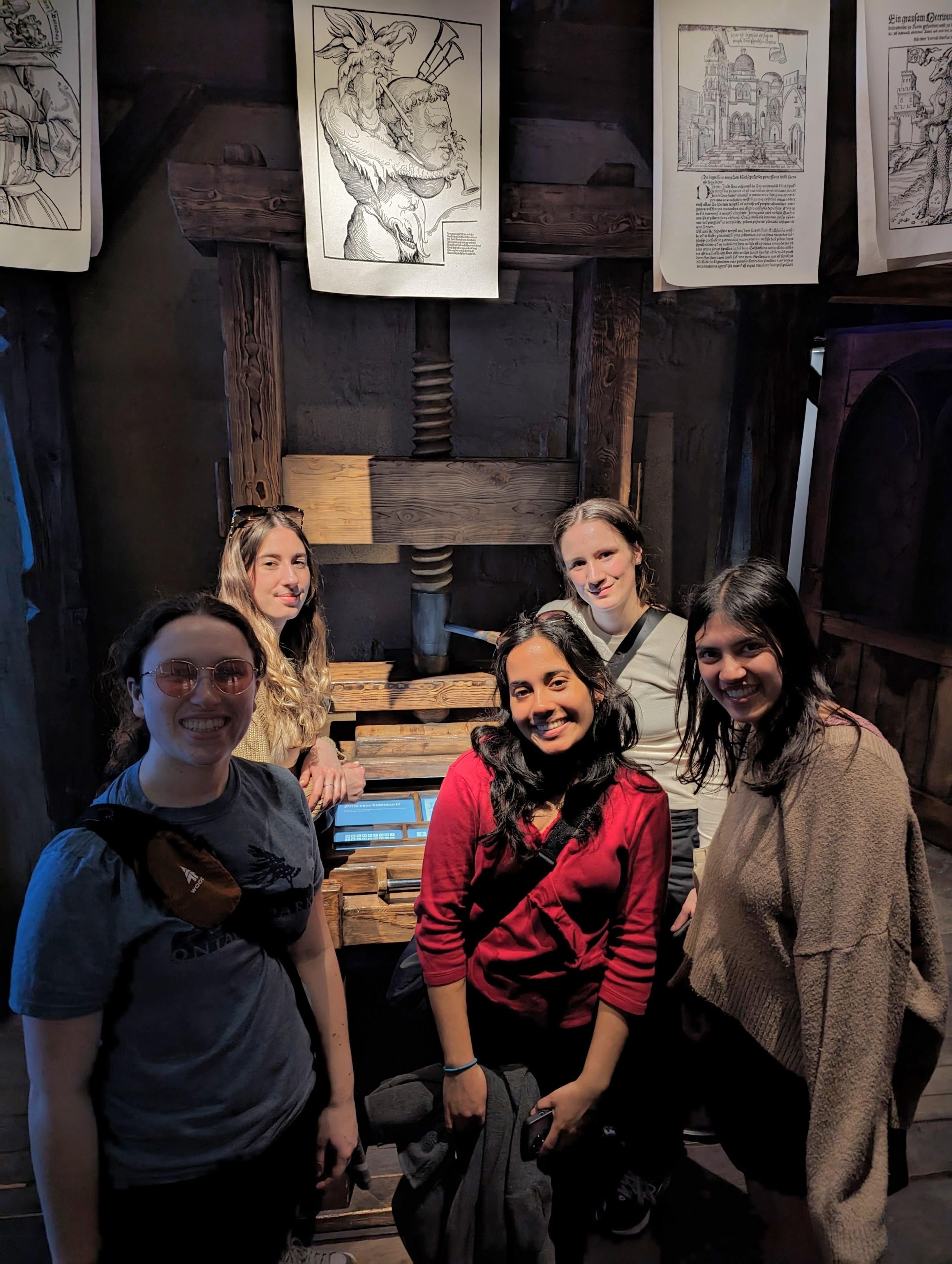 Five students pose in front of dragon exhibit