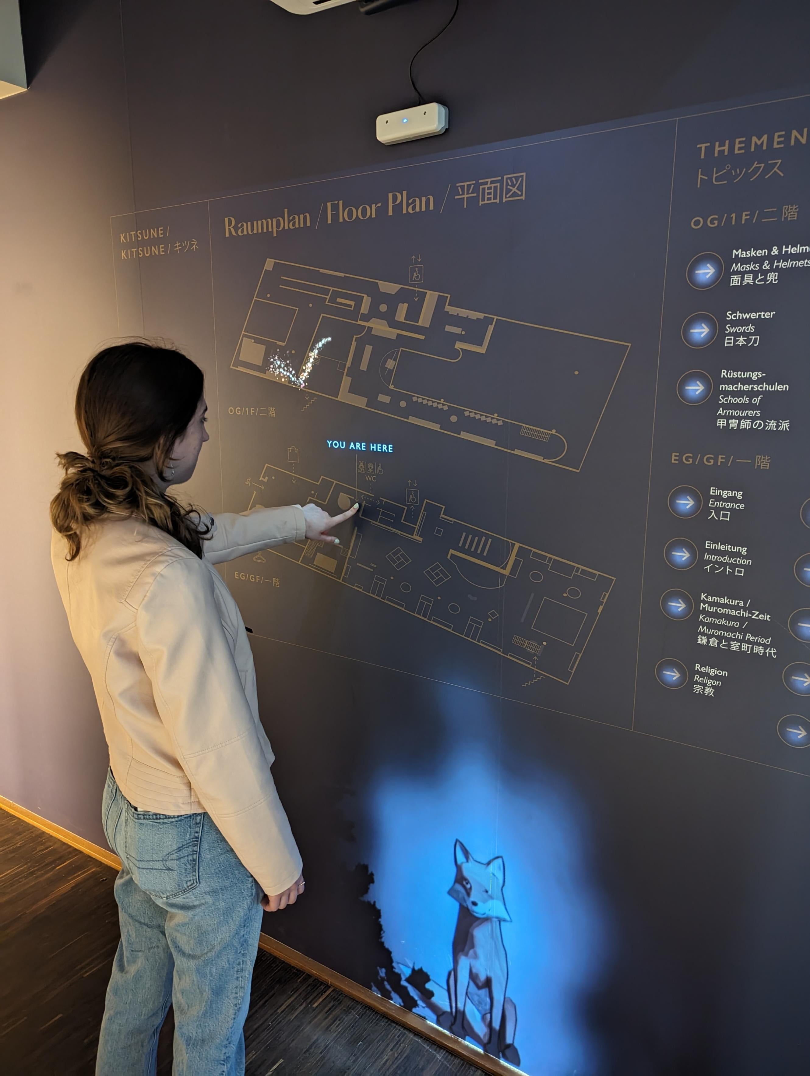 Student touching interactive floor plan at samurai museum