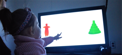 Little girl pointing at screen during a study