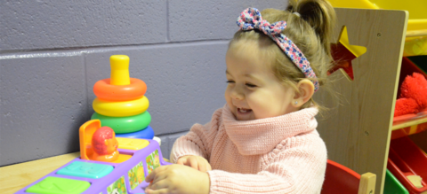 Little girl playing with a pop-up toy