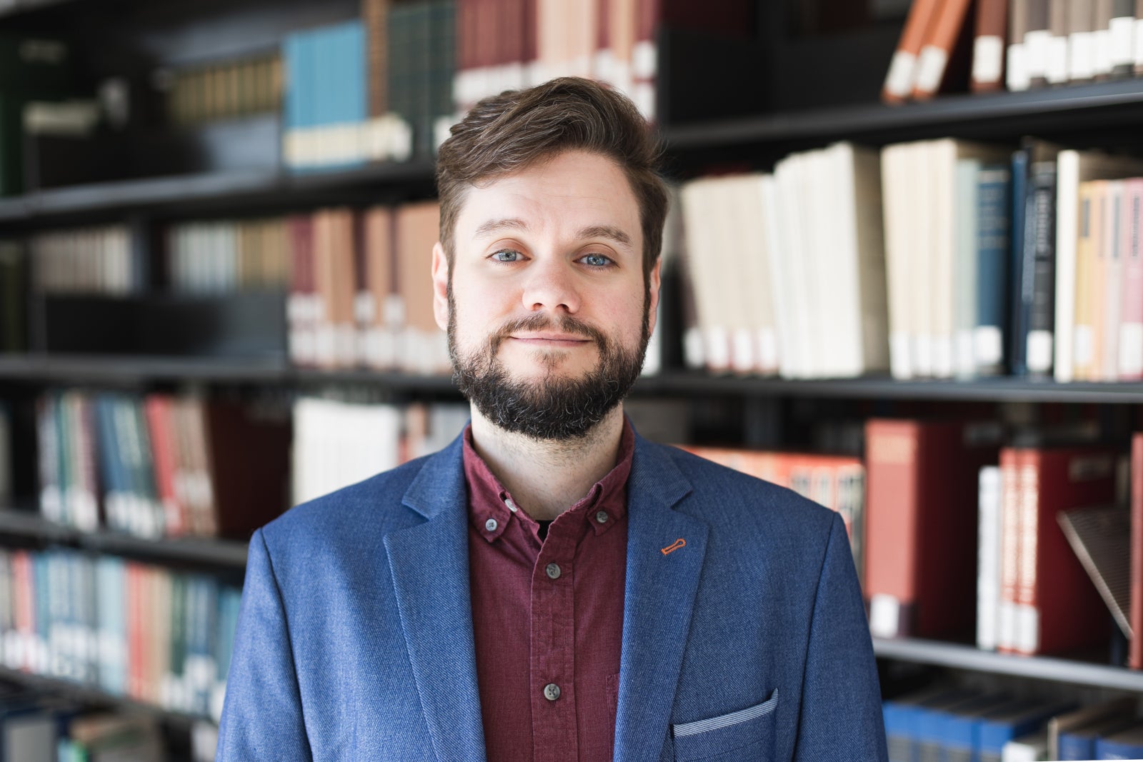 Michael Clark, a white male with short wavy brown hair and a short brown beard, wearing a blue jacket and red shirt.
