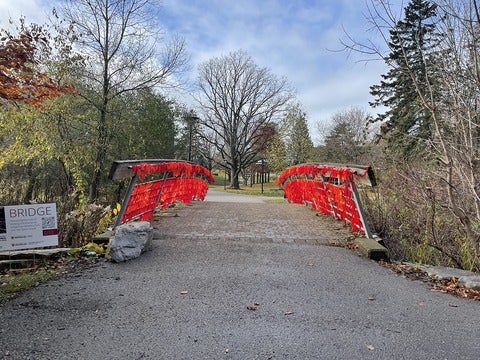 A small pedestrian bridge with bright red fabric on the railings