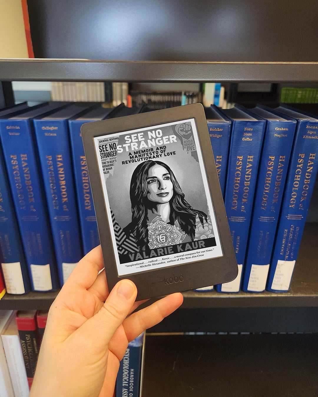 a hand holding an e-reader displaying the cover of "See No Stranger" by Valarie Kaur