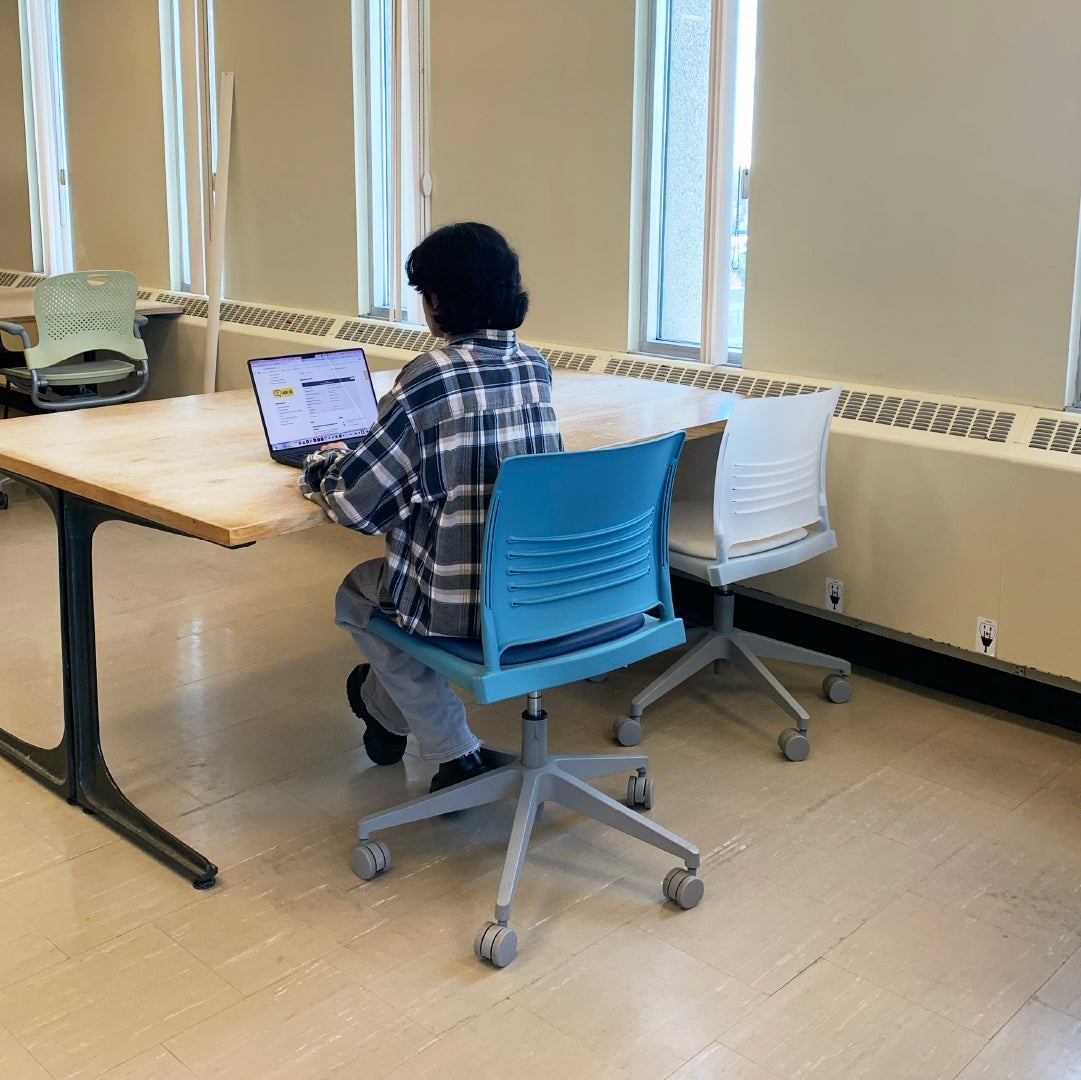 student sitting in a new chair at Dana Porter Library