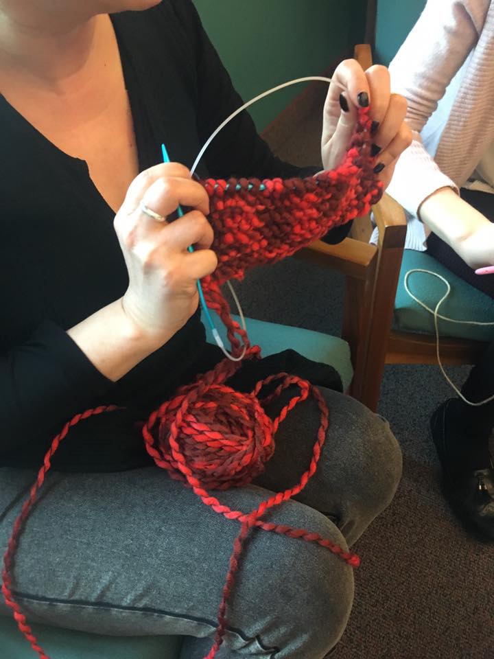Collegues help each other knitting