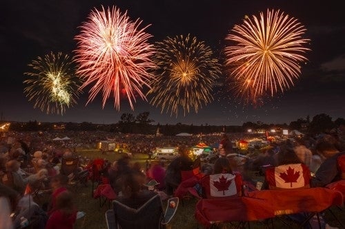 Fireworks above a crowd. Many Canadian flags are visible.