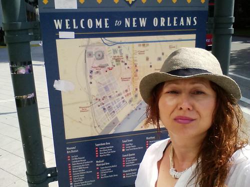 Staff member Steph (author of this post) stands in front of a New Orleans welcome map.