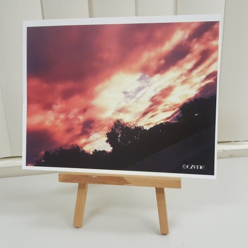 Photograph of a red sunset behind clouds.