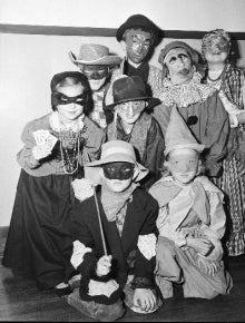 A group of children pose together dressed in Halloween costumes.