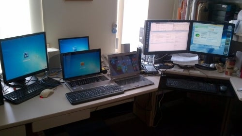 Many computers and devices on a desk in Library Facilities and Technology Services