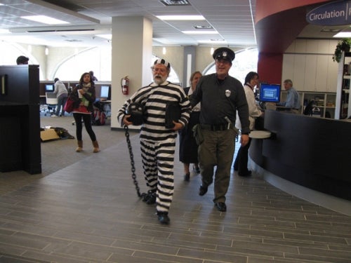 University Librarian dress up as a prisoner for a United Way campaign.