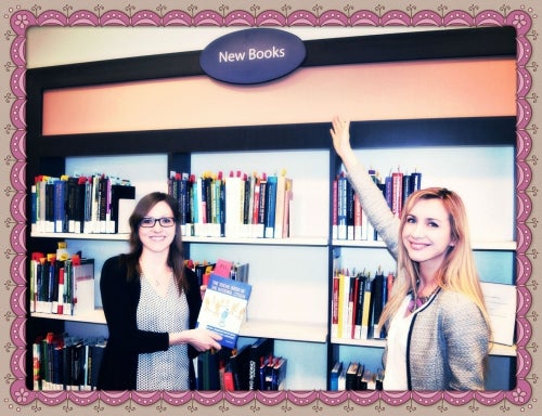 Two women standing in front of book shelf