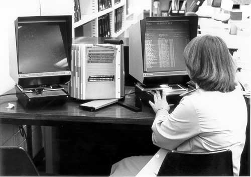 A woman working at one of our old fashioned black microfiche readers.