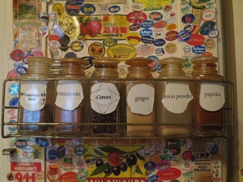 Spice rack with lots of stickers behind it.