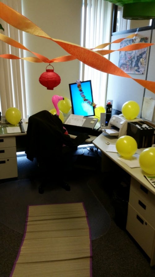 Ted Harms' office decorated with balloons and streamers. A blow-up flamingo sits in his desk chair.