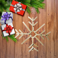 snowflake made out of popsicle sticks on a wooden table with presents