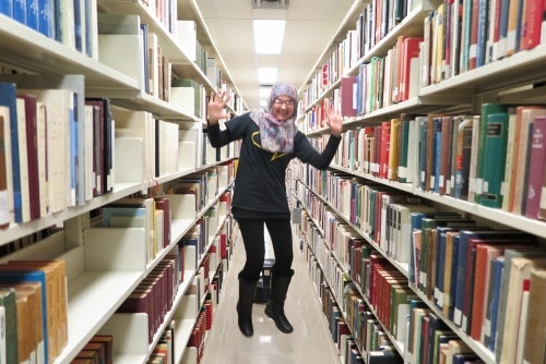 Rabia jumping in the book stacks in Dana Porter Library 