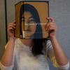 Person holding the book "narative of citizenship' in front of their face