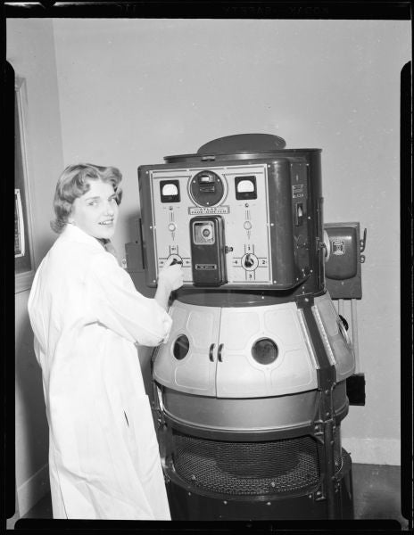 woman in lab coat next to a machine