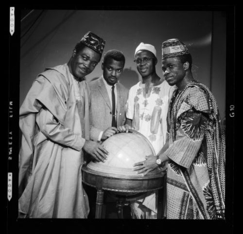 Four members of the Africa Student Federation posing for a photo while standing in traditional dress.