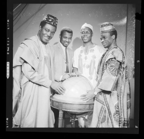 Four members of the Africa Student Federation posing for a photo while standing and smiling in traditional dress.