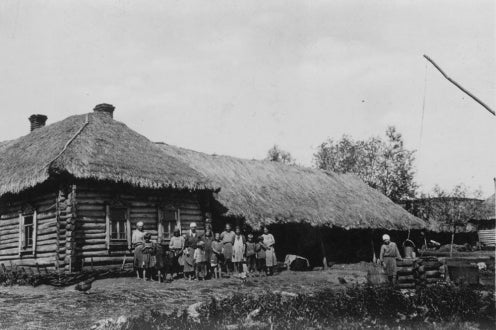 peasants posing in front of village building